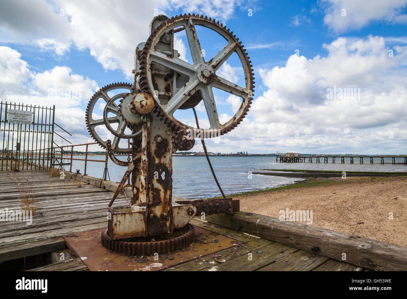 The slowly decaying piers at Shotley Gate in Suffolk old crane on harbour Stock Photo