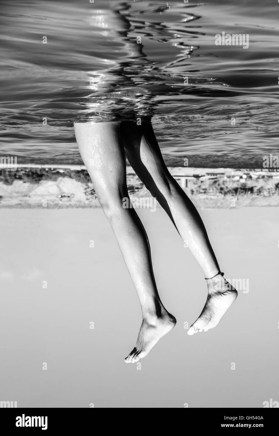 Legs sticking out of the sea Stock Photo