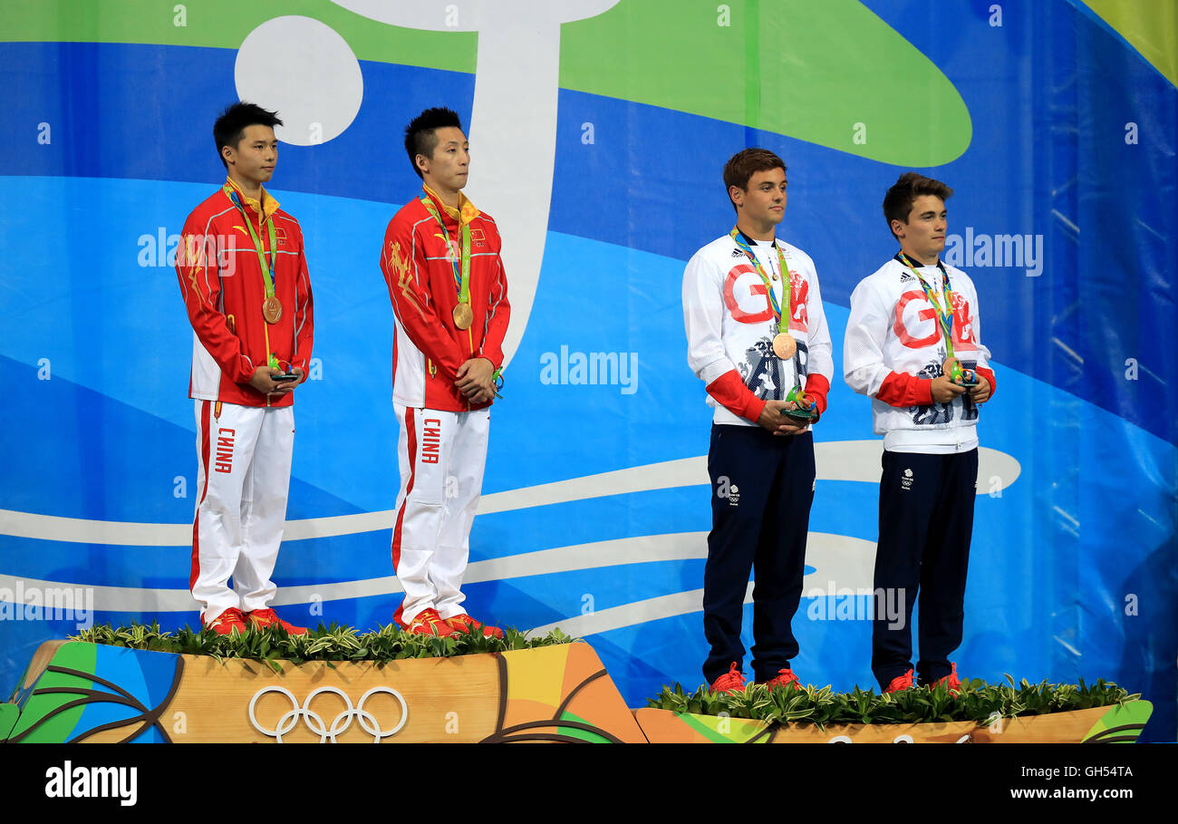 Great Britain's Tom Daley (second right) and Daniel Goodfellow (right) celebrate with their bronze medals alongside China's gold medal winners Aisen Chen (left) and Yue Lin (second left) on the podium after the Men's Synchronised 10m Platform Final at the Maria Lenk Aquatics Centre on the third day of the Rio Olympic Games, Brazil. Stock Photo