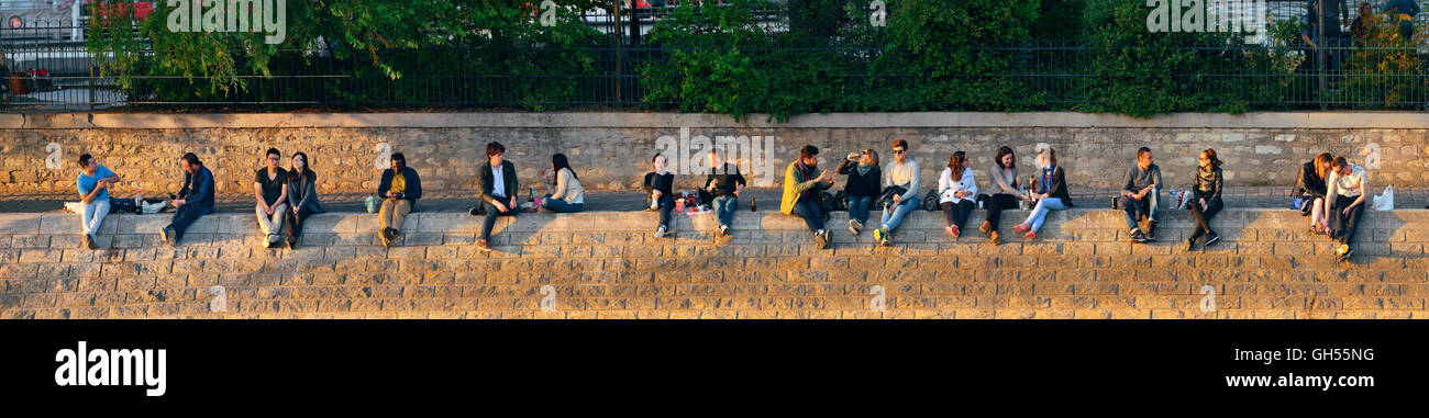 PARIS, FRANCE - MAY 13: People enjoy sunset light by River Seine on May 13, 2015 in Paris. With the population of 2M, Paris is the capital and most-populous city of France Stock Photo