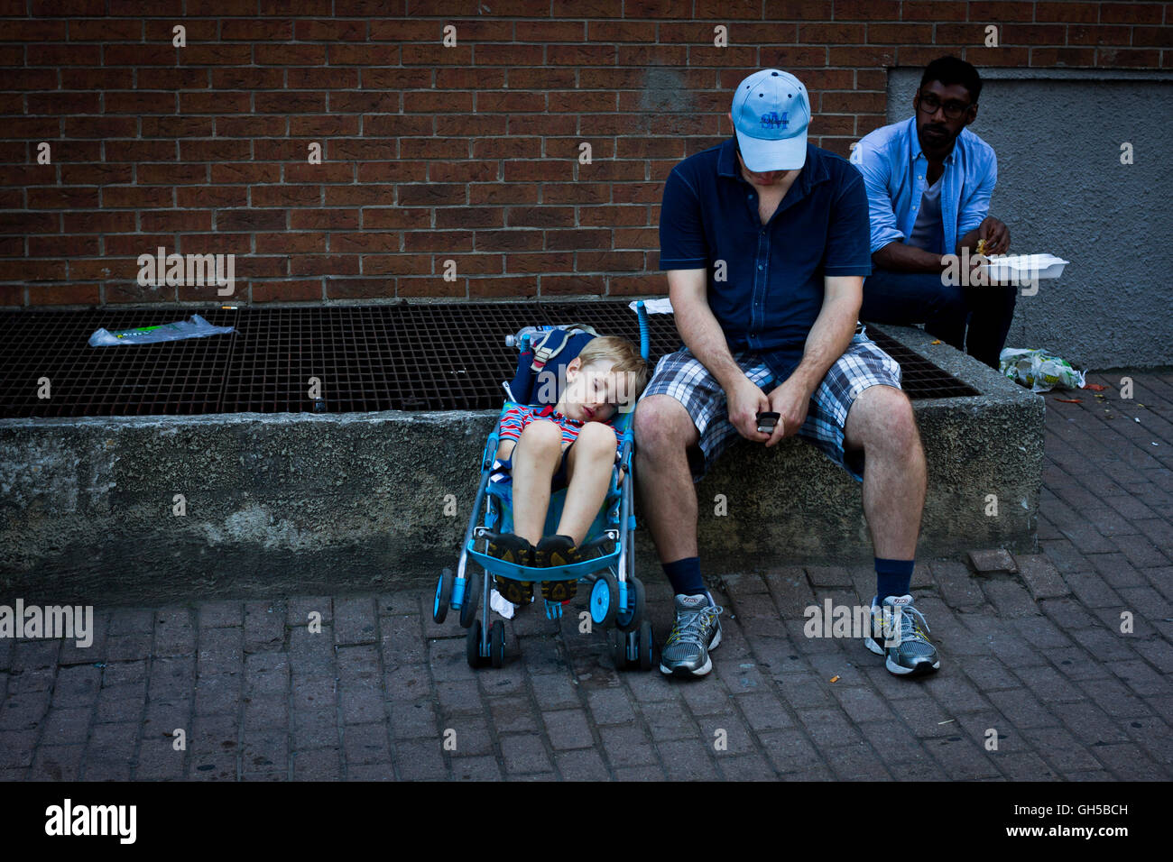 A tired young boy sleeps in a buggy at the Pride festival in Toronto, Canada. Stock Photo