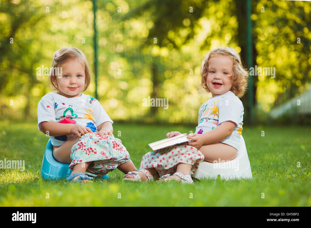 The two little baby girls sitting on pots Stock Photo Alamy