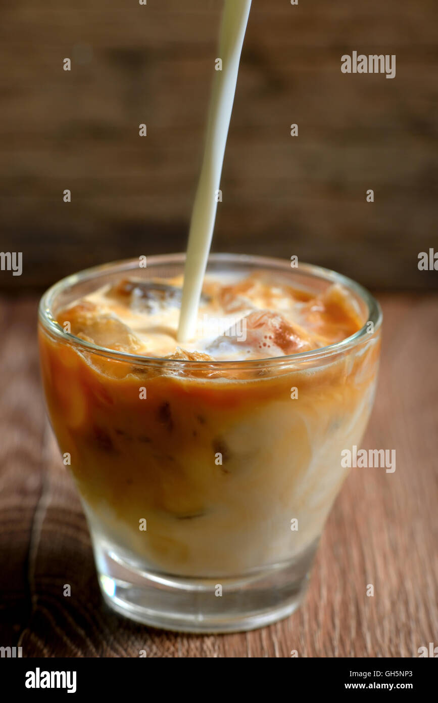 Iced coffee with milk on wooden table Stock Photo