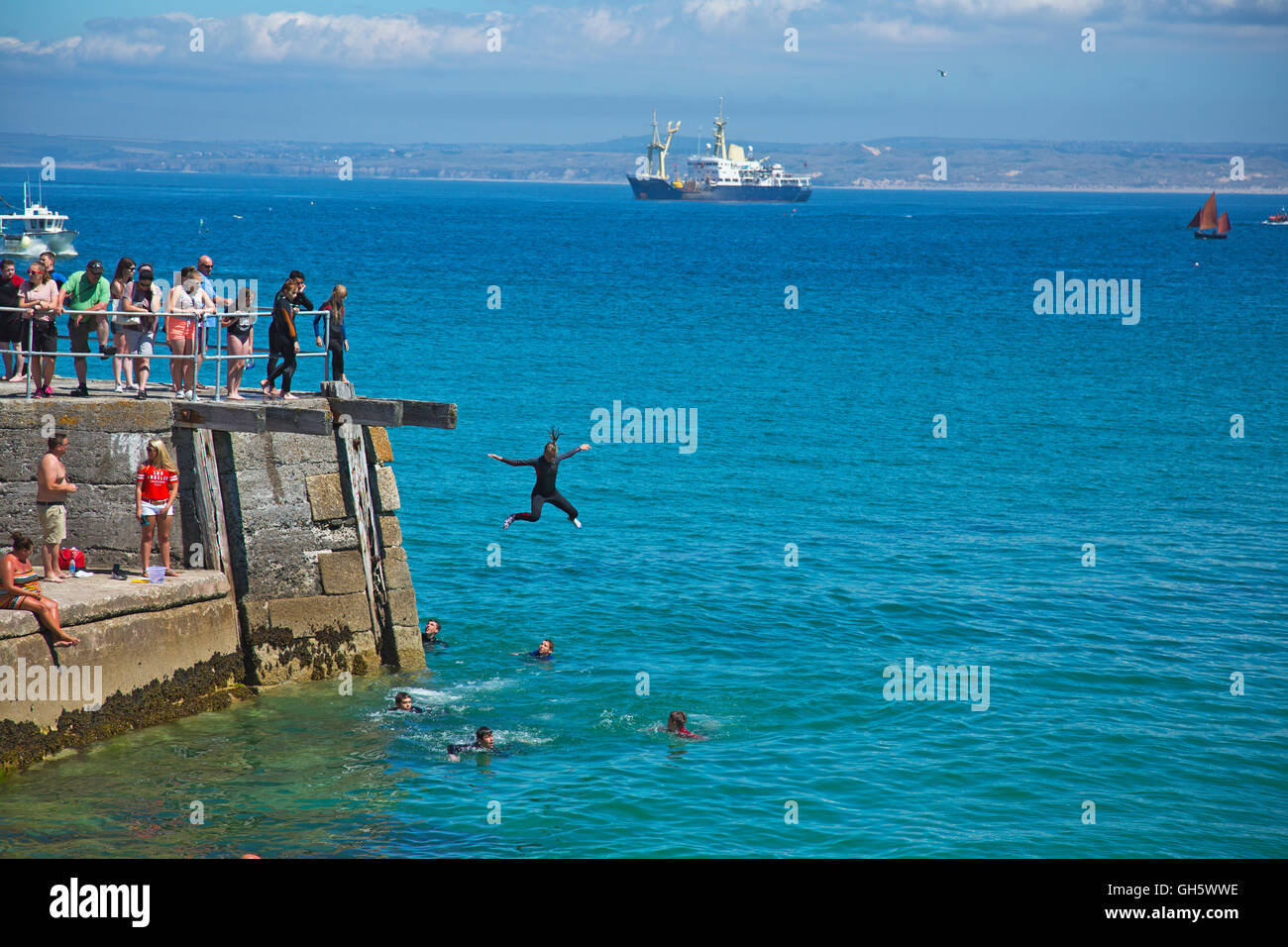 Kids tombstoneing of the harbor wall in St Ives in Cornwall Stock Photo