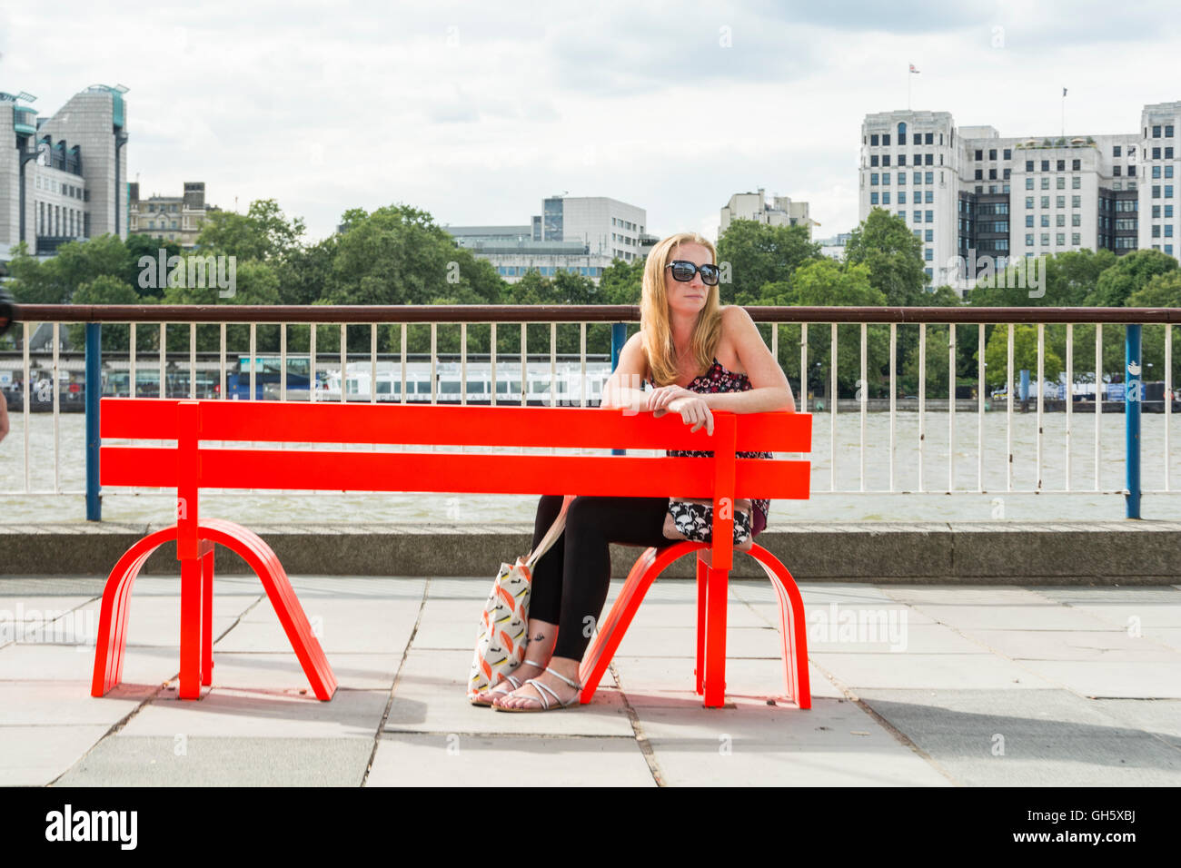 A woman sitting on one of Jeppe Hein's Modified Social Benches on London's South Bank, SE1, UK Stock Photo
