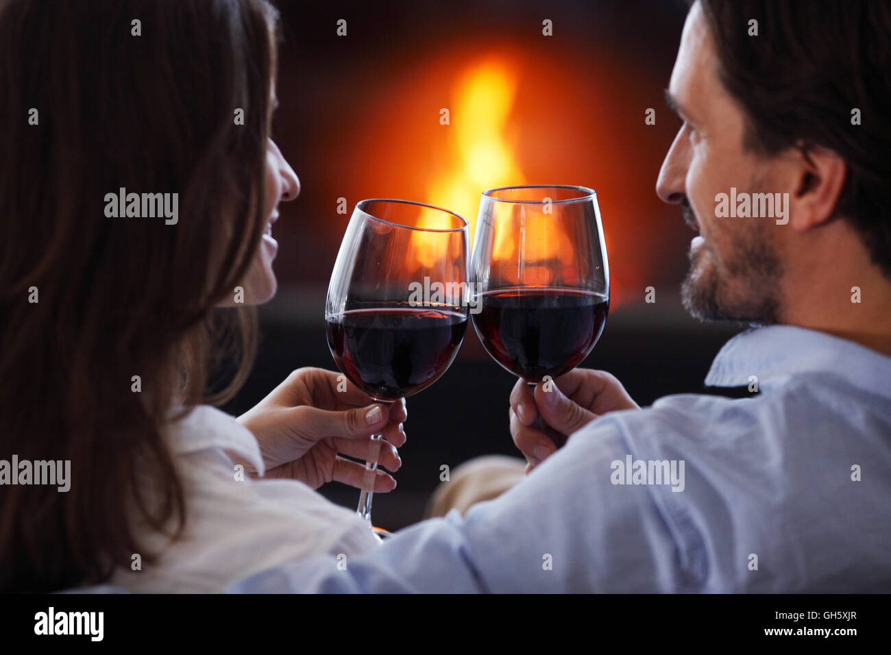 Romantic couple drinking wine at home near fireplace Stock Photo Alamy