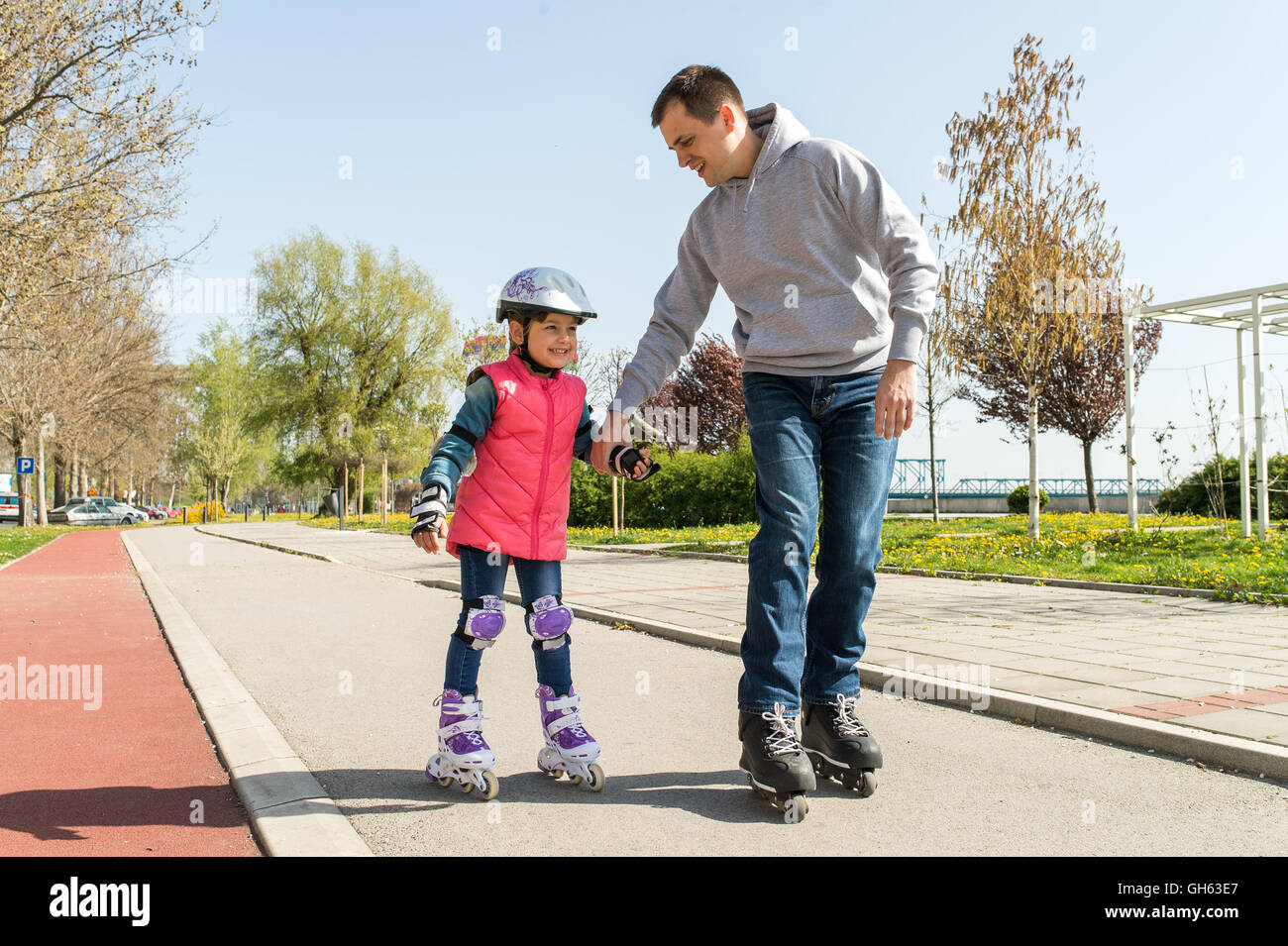 father teaching little daugther to roller skate Stock Photo Alamy