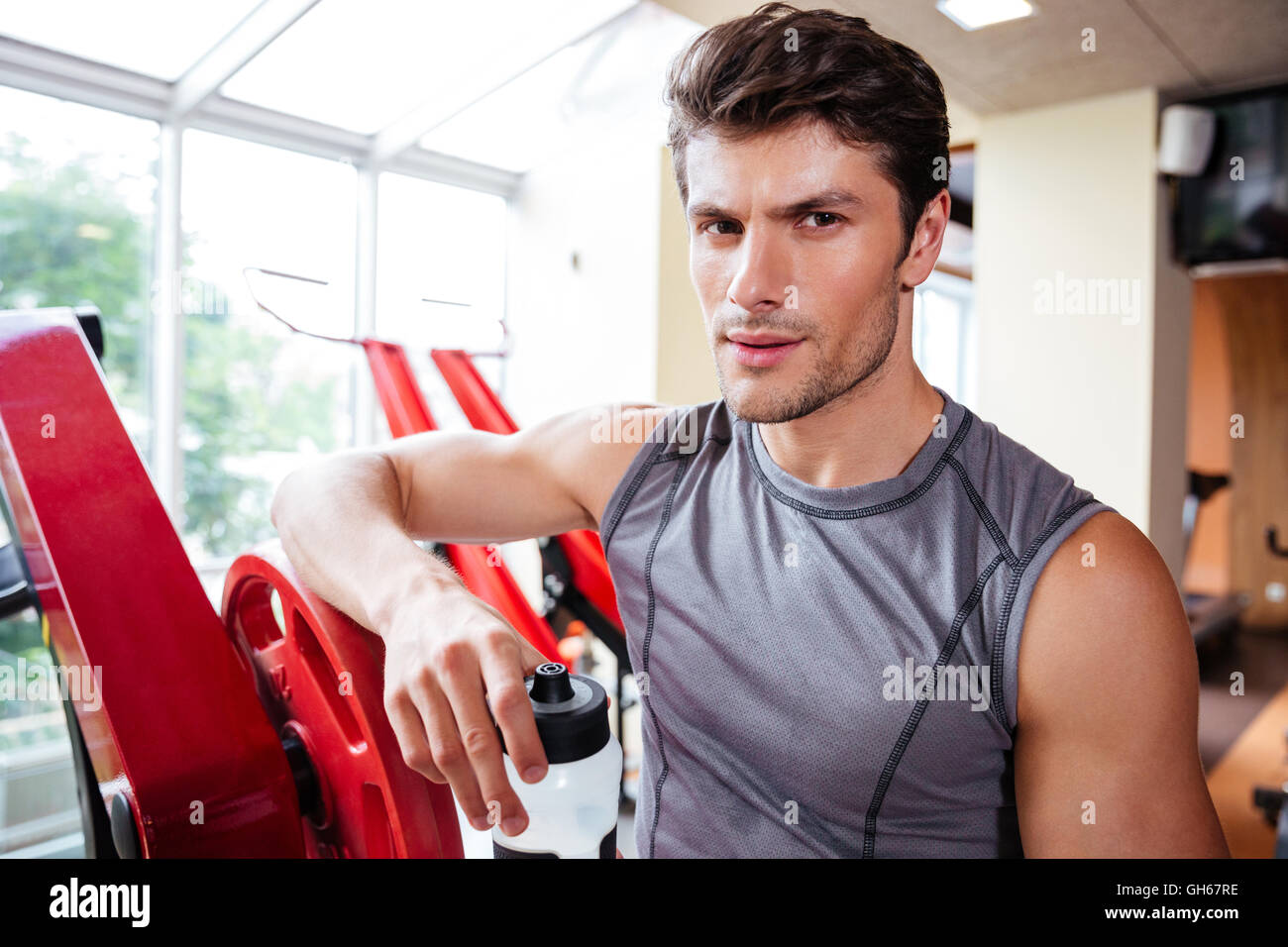 Young fitness black man holding a water bottle impressed holding copy space  on palm. Stock Photo