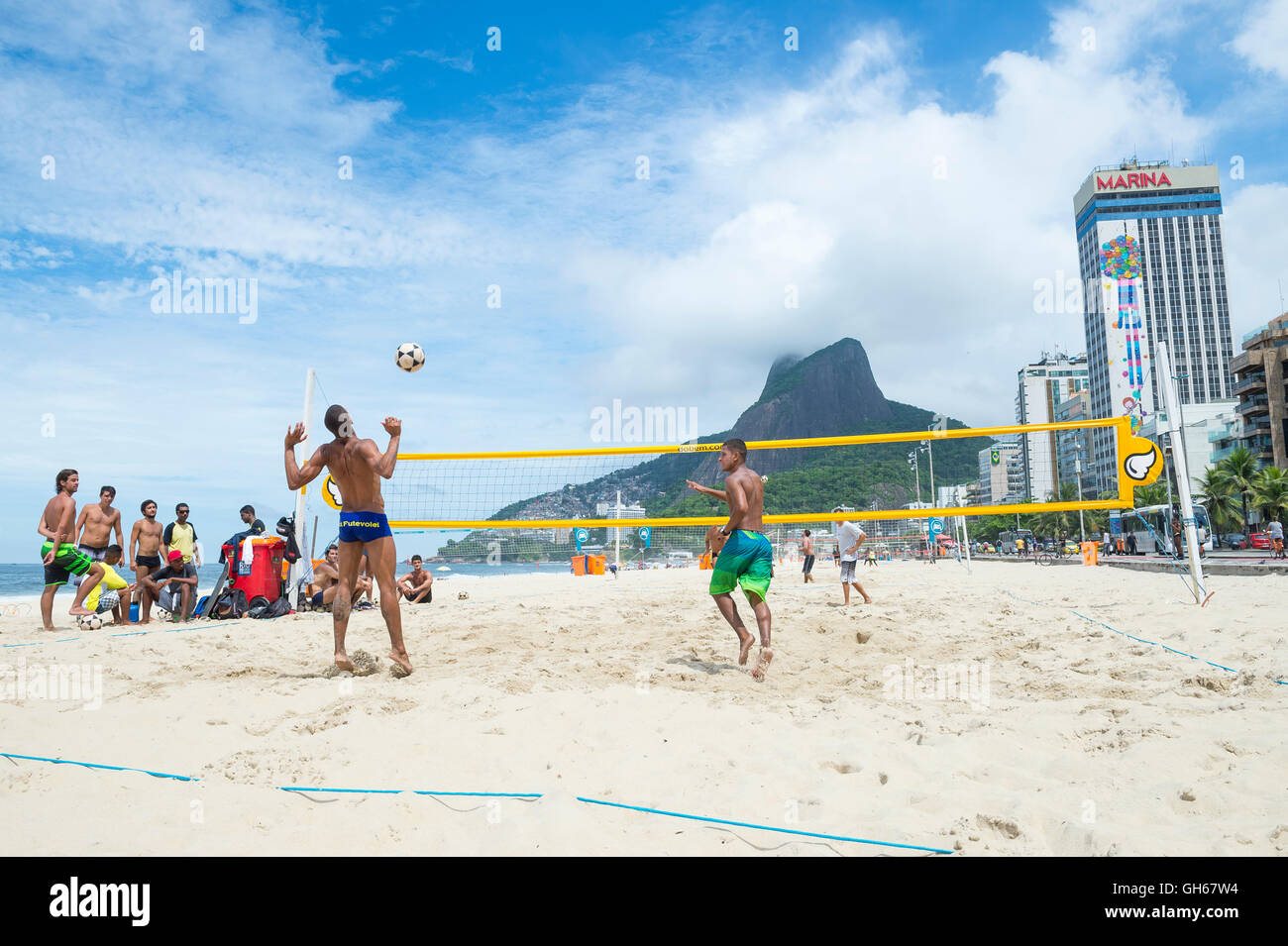 RIO DE JANEIRO - MARCH 17, 2016: Young Brazilian men play a game of futevolei (footvolley) on Ipanema Beach. Stock Photo