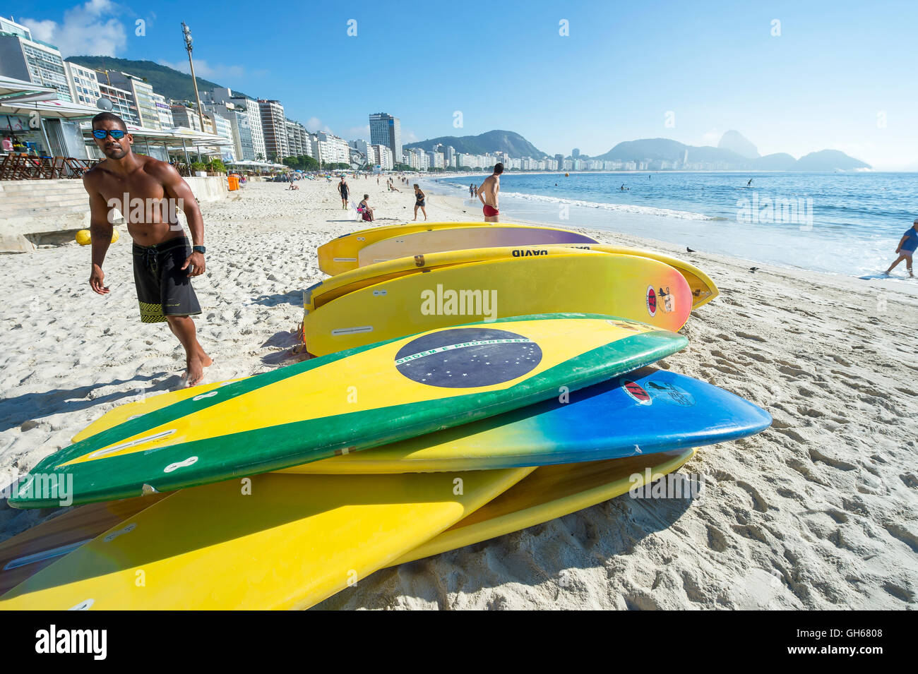 RIO DE JANEIRO - APRIL 5, 2016: A worker sets out stand up paddle surfboards for rental customers on Copacabana Beach. Stock Photo