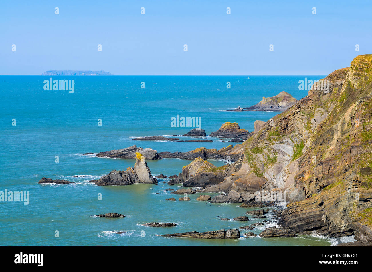 The North Devon coastline at Hartland Quay, England with Lundy Island visible on the horizon. Stock Photo