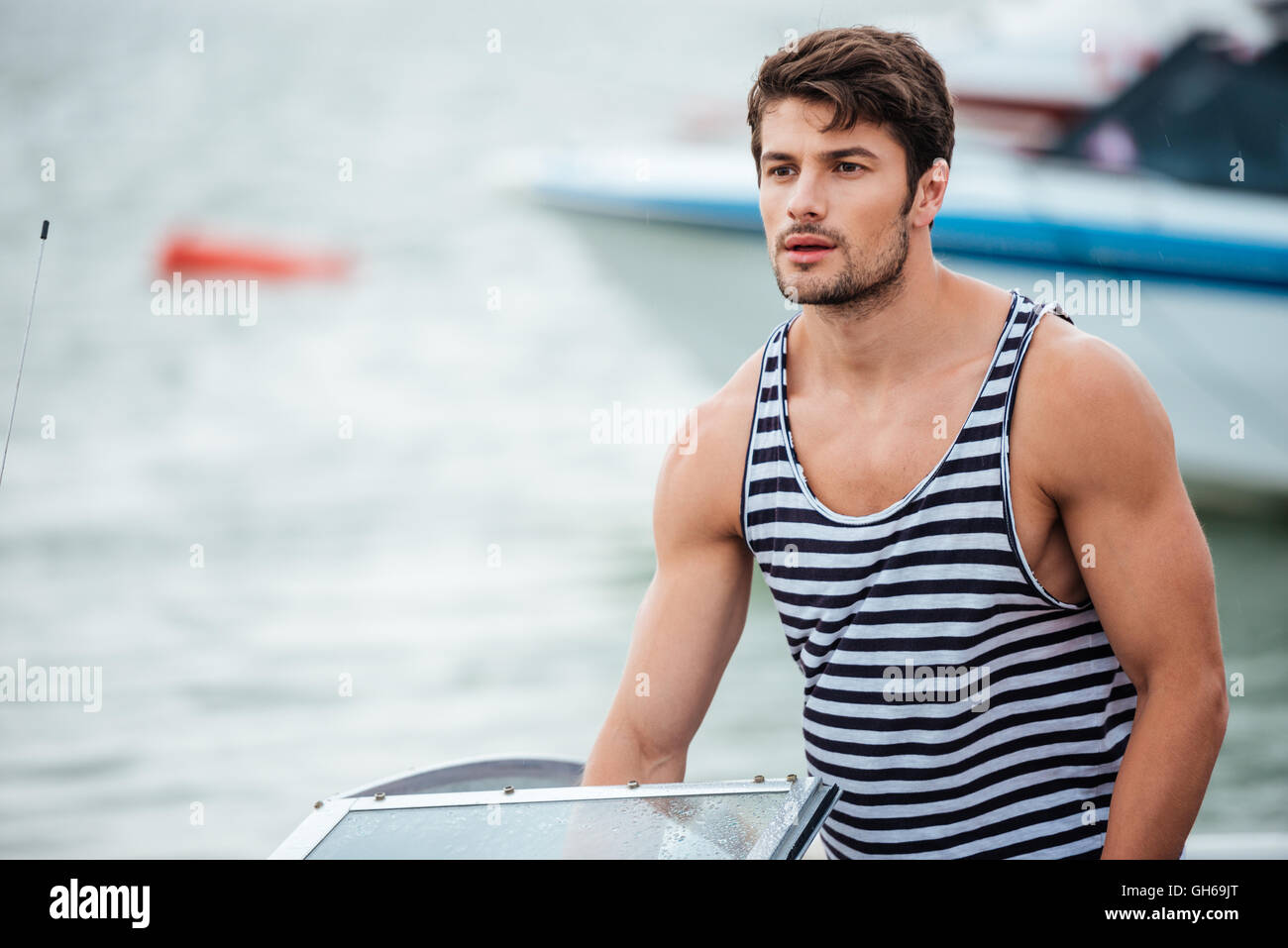 Young handsome bearded sailor man driving his motor boat Stock Photo ...