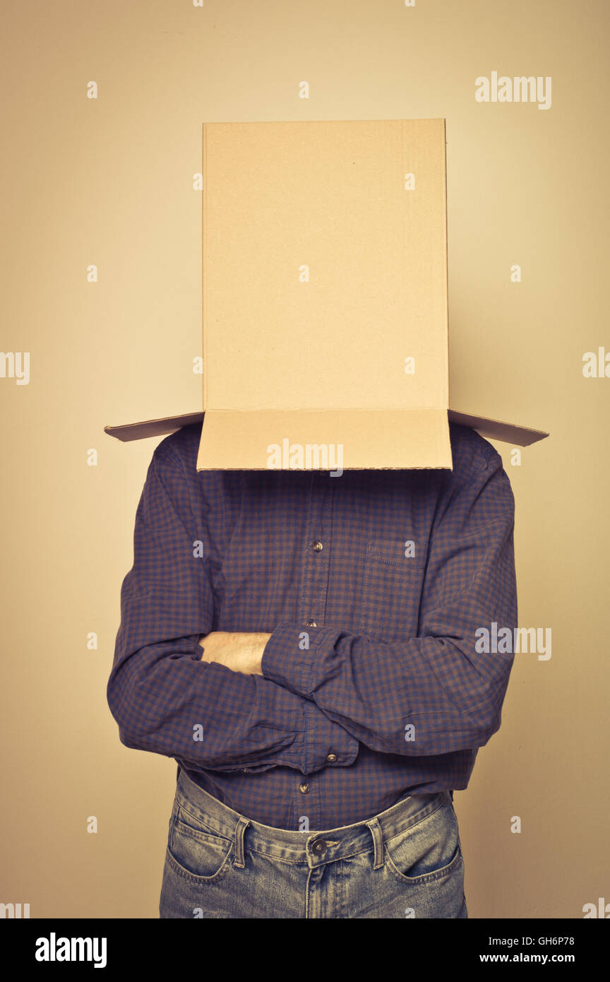 man with a blank box over his head, various concept: thinking, shy, afraid Stock Photo