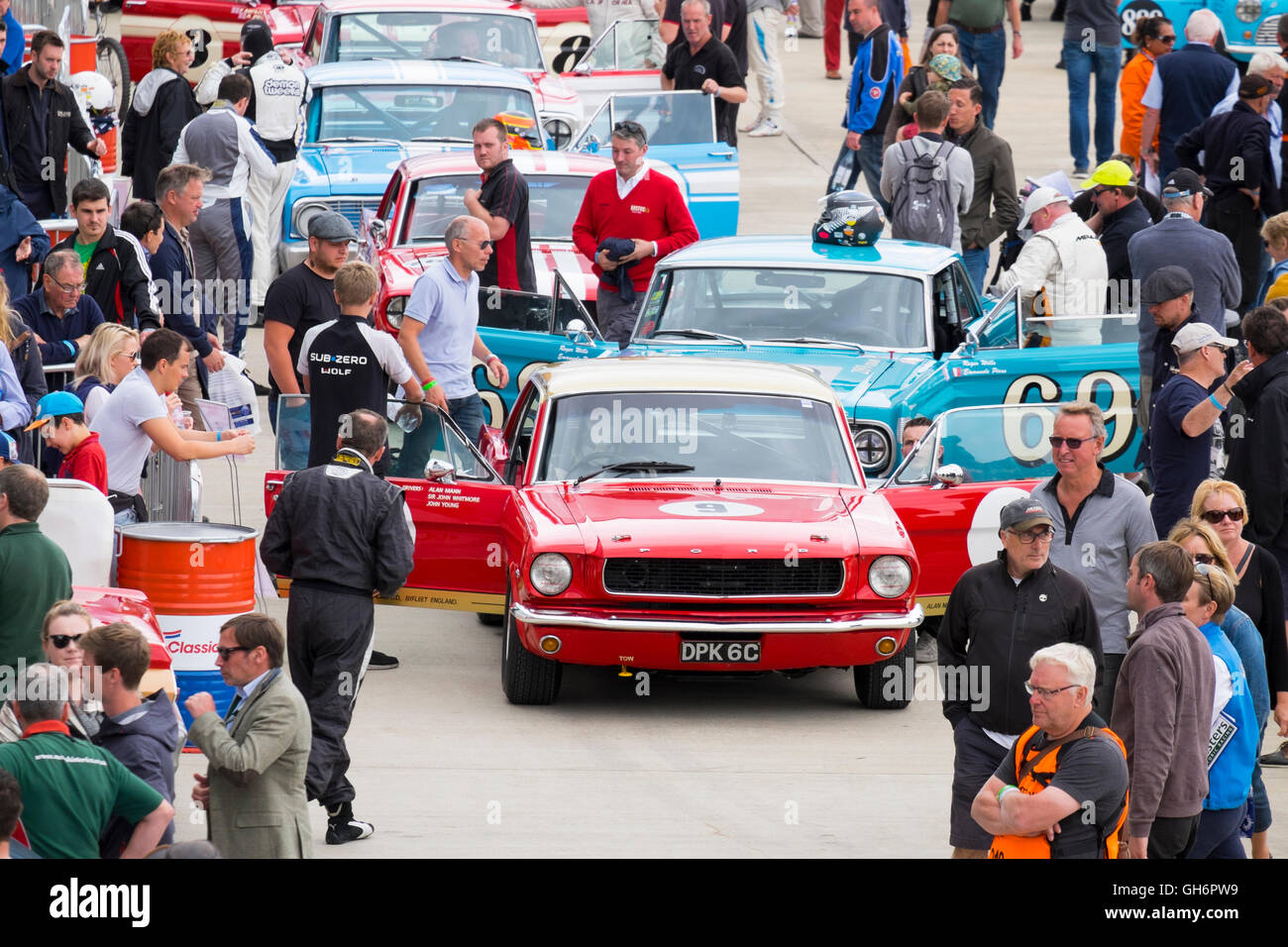 A Ford Mustang at the front of a line of classic touring cars in the paddock at the annual Silverstone Classic event, UK Stock Photo