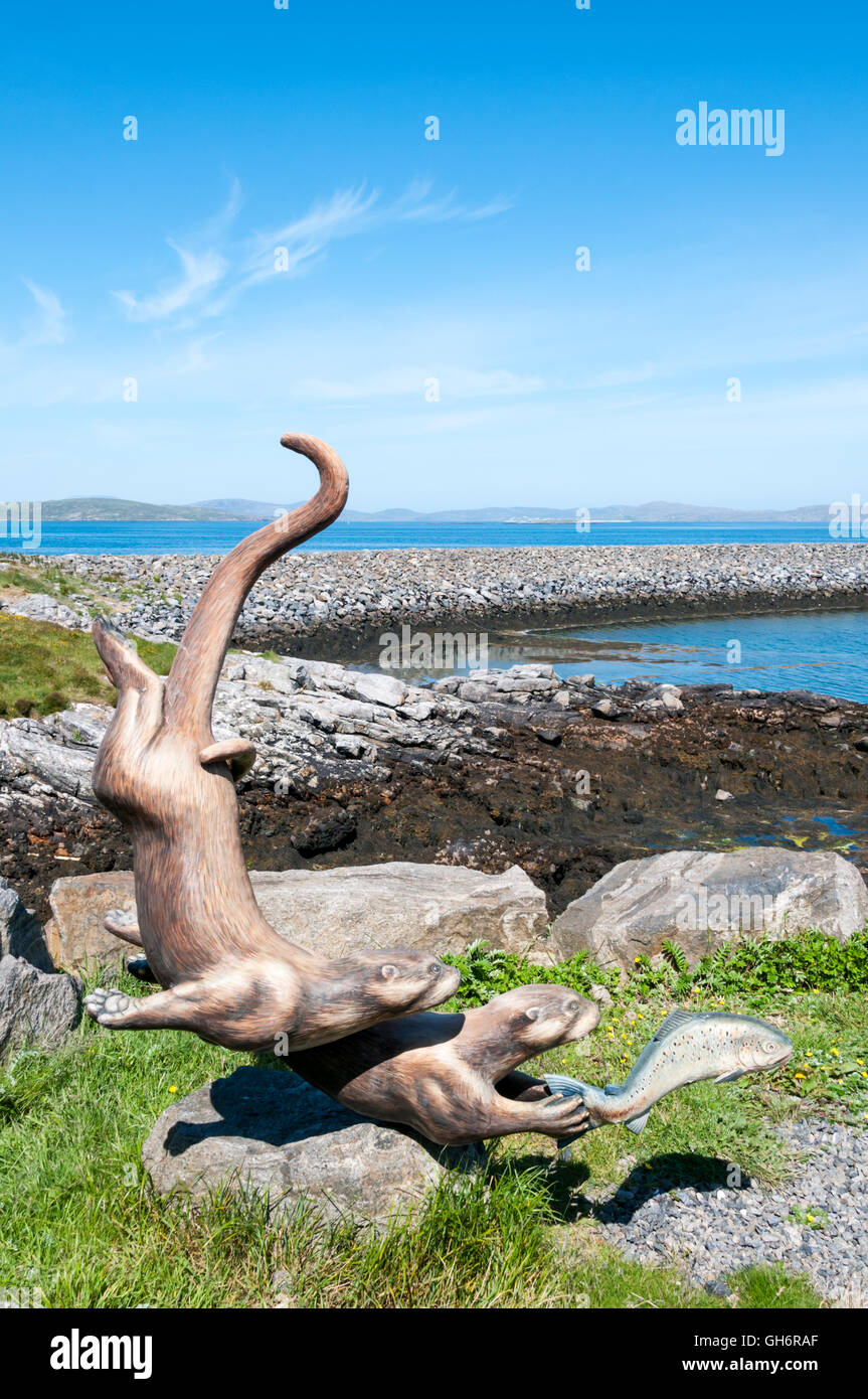 The sculpture by Lewis artist Iain Brady of two otters chasing a fish at the Aird Mhor ferry terminal on the island of Barra. Stock Photo