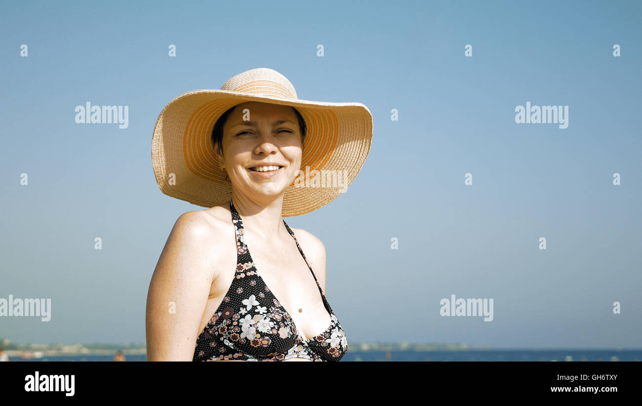 Woman standing on the beach with her fancy hat Stock Photo
