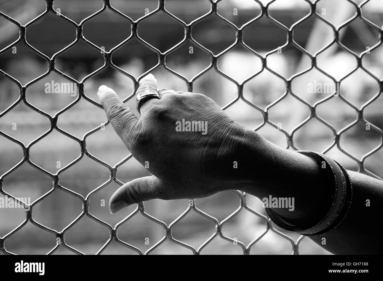 Hand of an Indian woman grabbing on to the window rails of the local train. Stock Photo