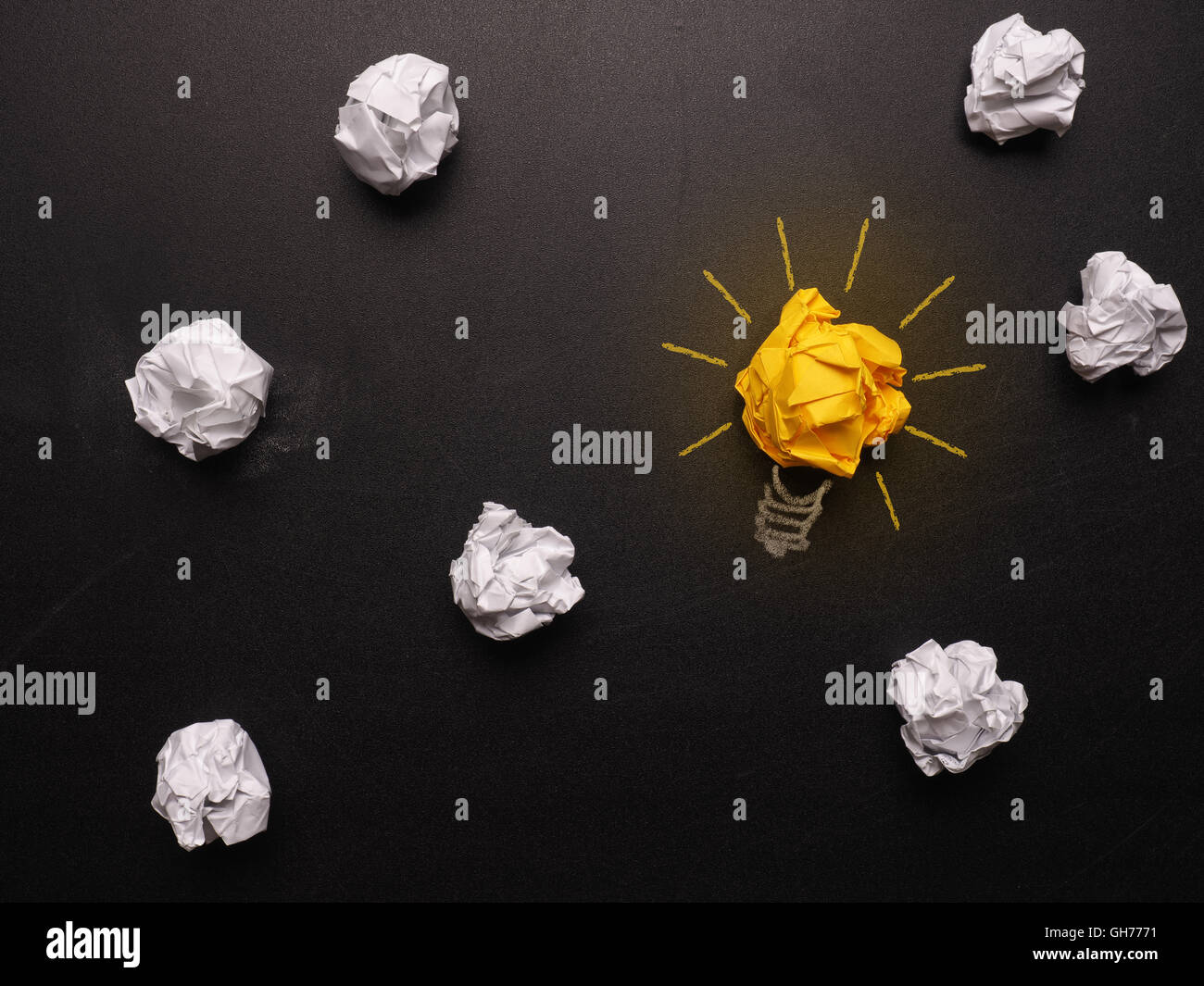 Crumpled paper on a chalkboard with a light bulb Stock Photo