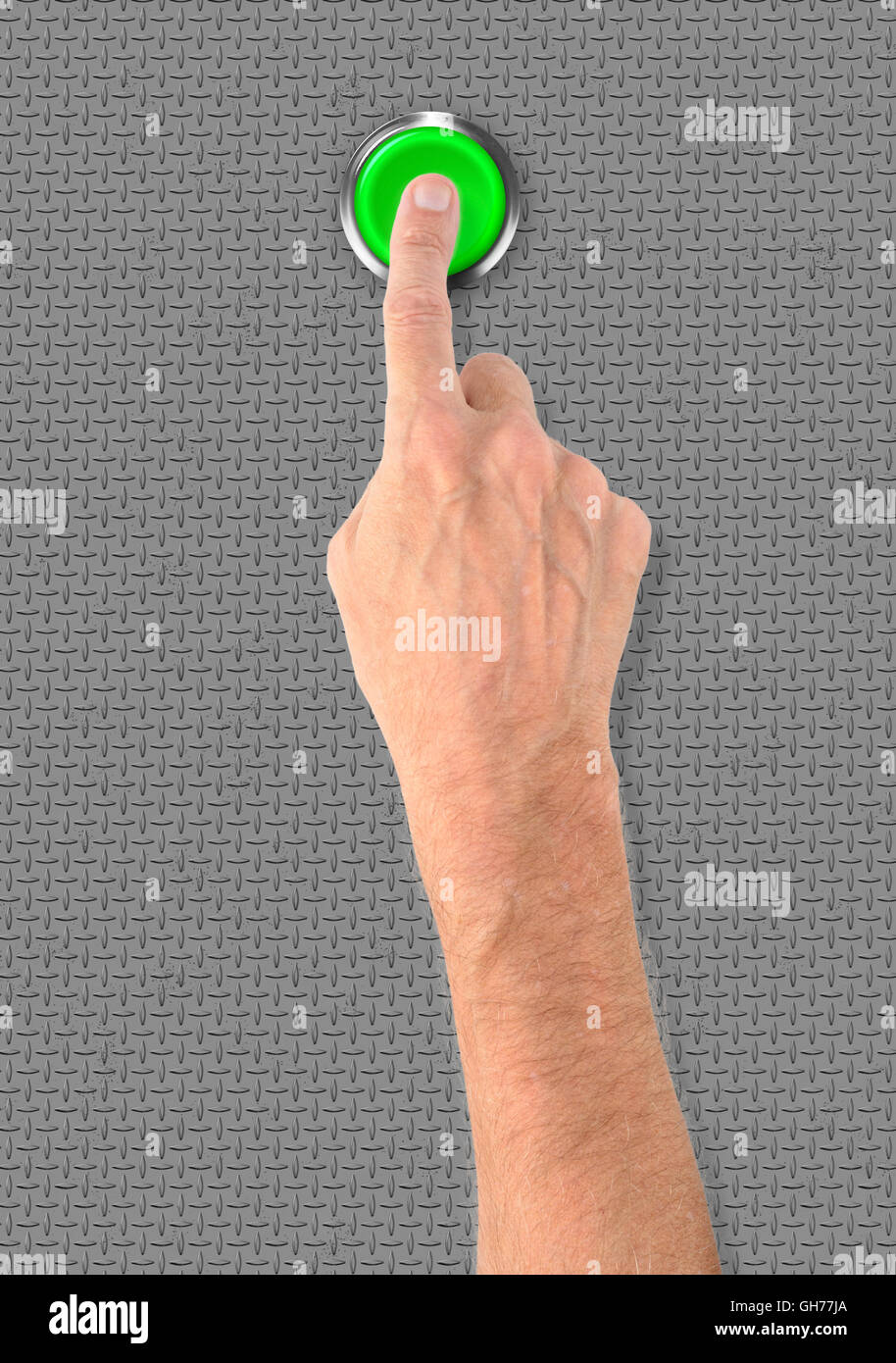 A man pushing a big green start stop alarm button with the finger Stock Photo