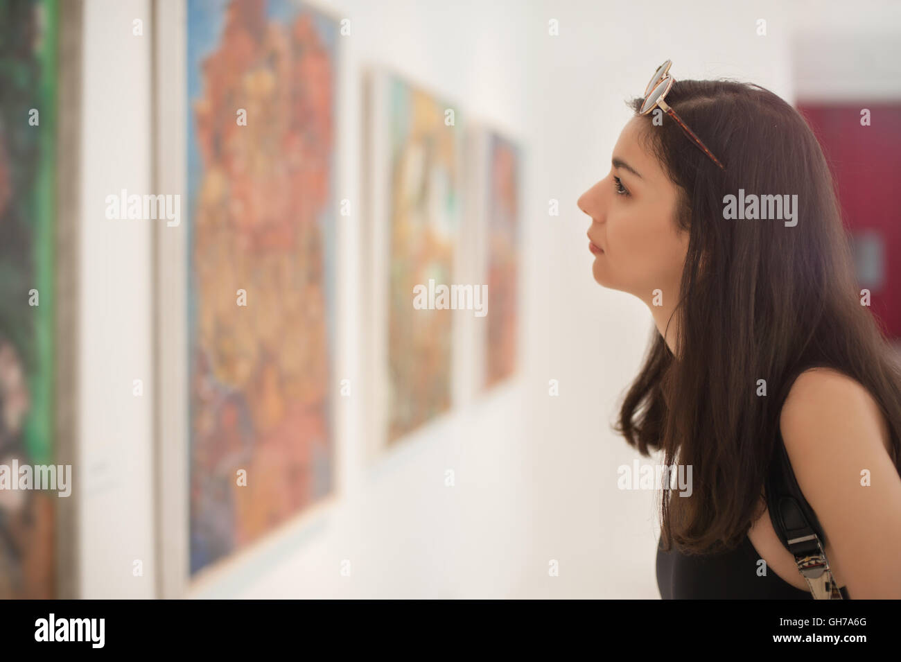 Young woman looking at modern painting in art gallery Stock Photo