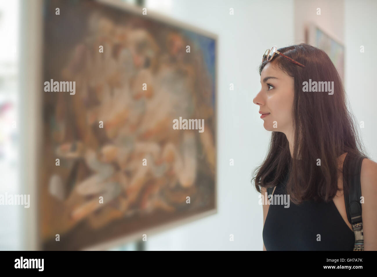 Young woman looking at modern painting in art gallery Stock Photo - Alamy