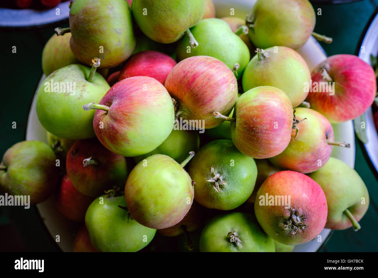 Red apple and green apple in basket with burlap background texture