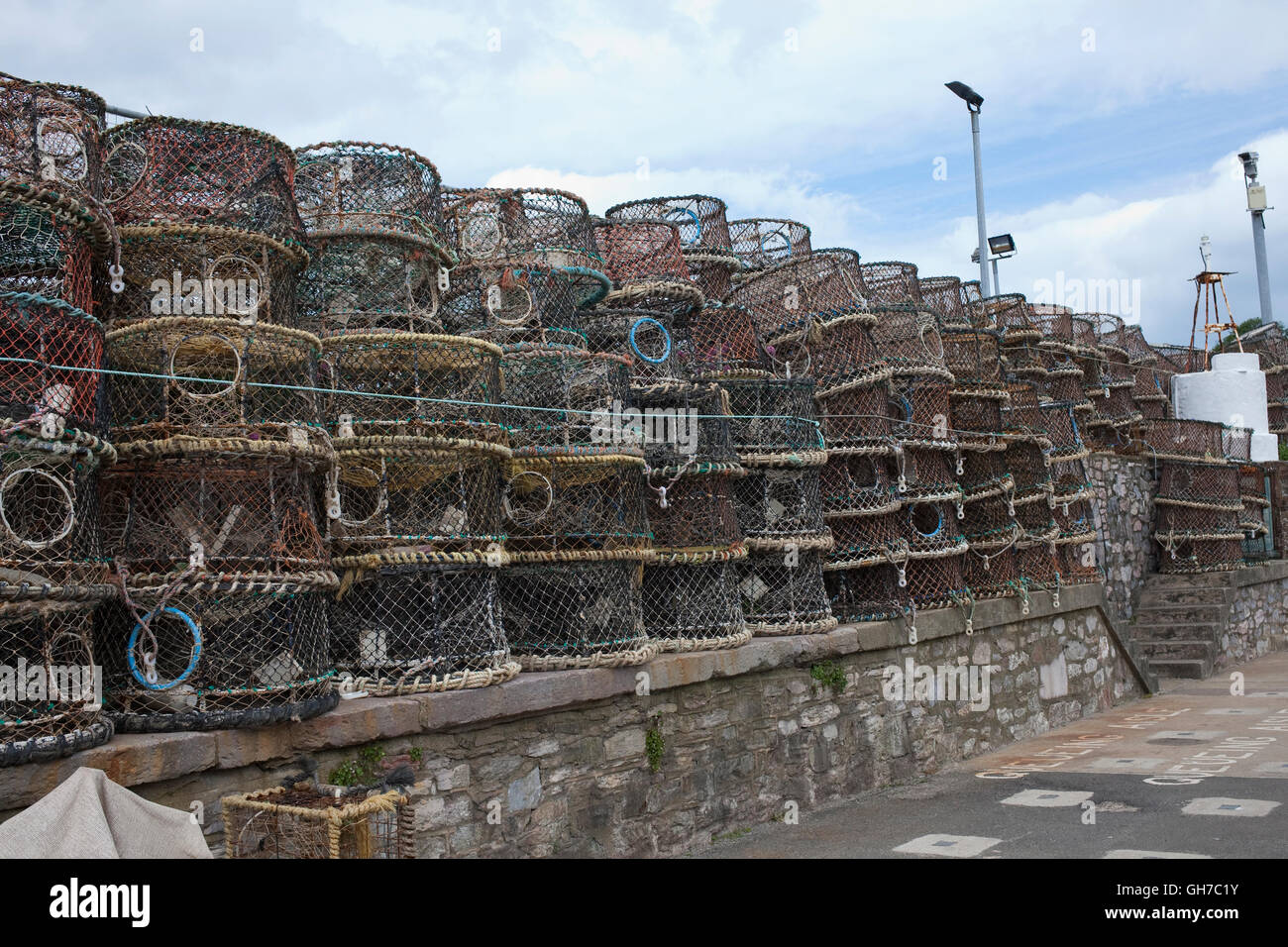 numerous lobster pots stacked on Brixhams Harbourside Stock Photo