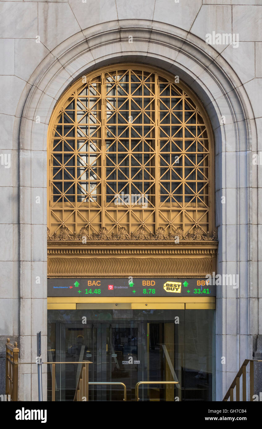 Entrance to New York Stock Exchange at 11 Wall Street, showing digital ticker tape display Stock Photo