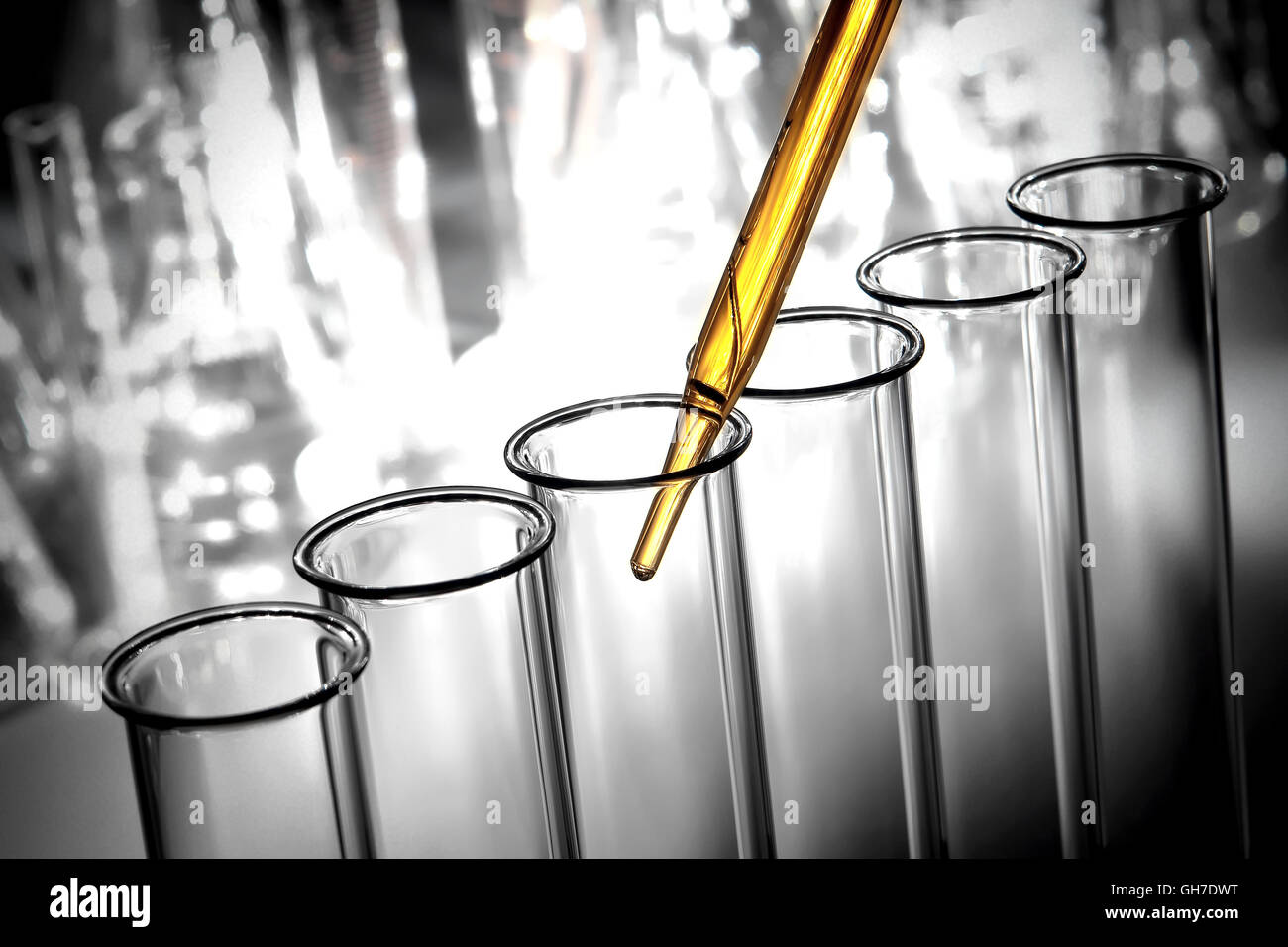 Laboratory pipette over glass test tubes filled with chemical solution ...
