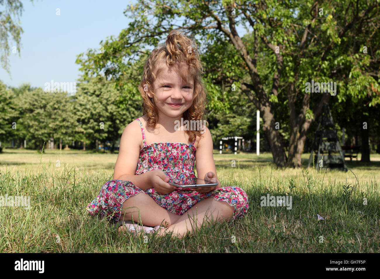 little girl with tablet pc in park Stock Photo - Alamy.