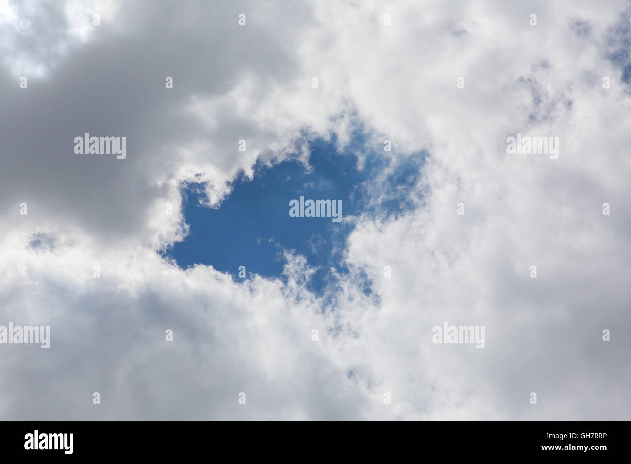 Gap in the grey clouds through to the blue sky Stock Photo