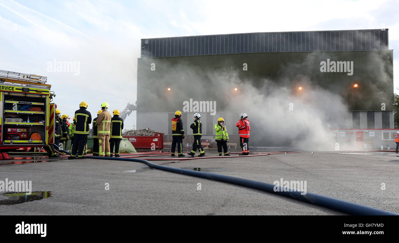 Marchwood, Hamphire, UK. 8th August 2016. Emergency crews from Hampshire fire and rescue service and South central  ambulance  service remain at the  cene of a  fire that broke out just after lunchtime today.  Fire crews have been brought from a far a field as Portsmouth to tackle the blaze at the fire at the recycling centre in East Road  Marchwood.  Eight fire engines two aerial ladders  and the incident command unit from Eastleigh been brought in to put out the fire out. Credit:  uknip/Alamy Live News Stock Photo