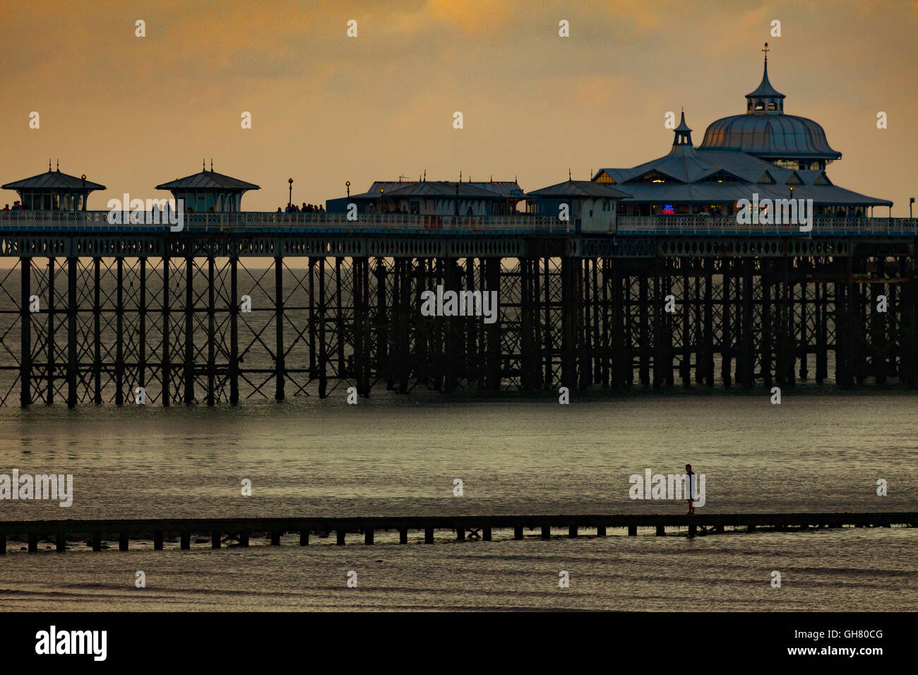 A young man trying his hand at crab fishing of a wooden jetty alongside