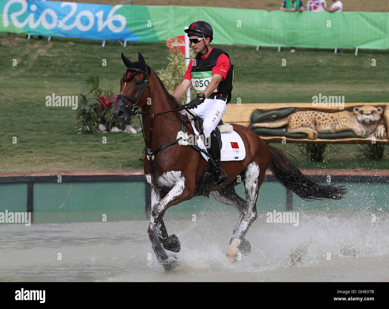 Rio de Janeiro, Brazil. 8th Aug, 2016. Alex Hua Tian of China on horse Don Geniro in action during the Eventing Cross Country of the Equestrian events at the Rio 2016 Olympic Games at the Olympic Equestrian Centre in Rio de Janeiro, Brazil, 8 August 2016. Photo: Friso Gentsch/dpa/Alamy Live News Stock Photo
