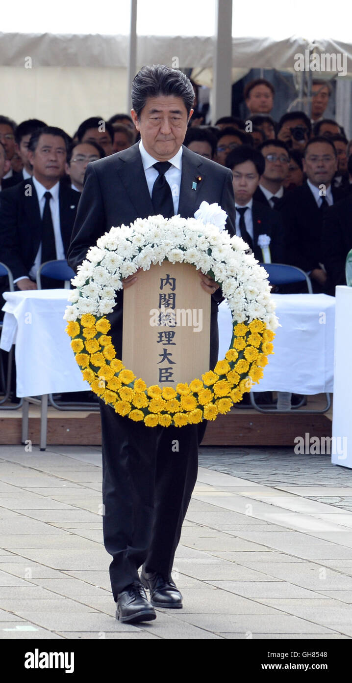 Nagasaki. 9th Aug, 2016. Japanese Prime Minister Shinzo Abe presents a wreath to atomic bombing victims during a ceremony commemorating the 71st anniversary of U.S. atomic bombing at the Peace Park in Nagasaki, on Aug. 9, 2016. To accelerate Japan's surrender in the World War II, the U.S. forces dropped two atomic bombs on Hiroshima and Nagasaki respectively on Aug. 6 and 9, 1945. Credit:  Ma Ping/Xinhua/Alamy Live News Stock Photo
