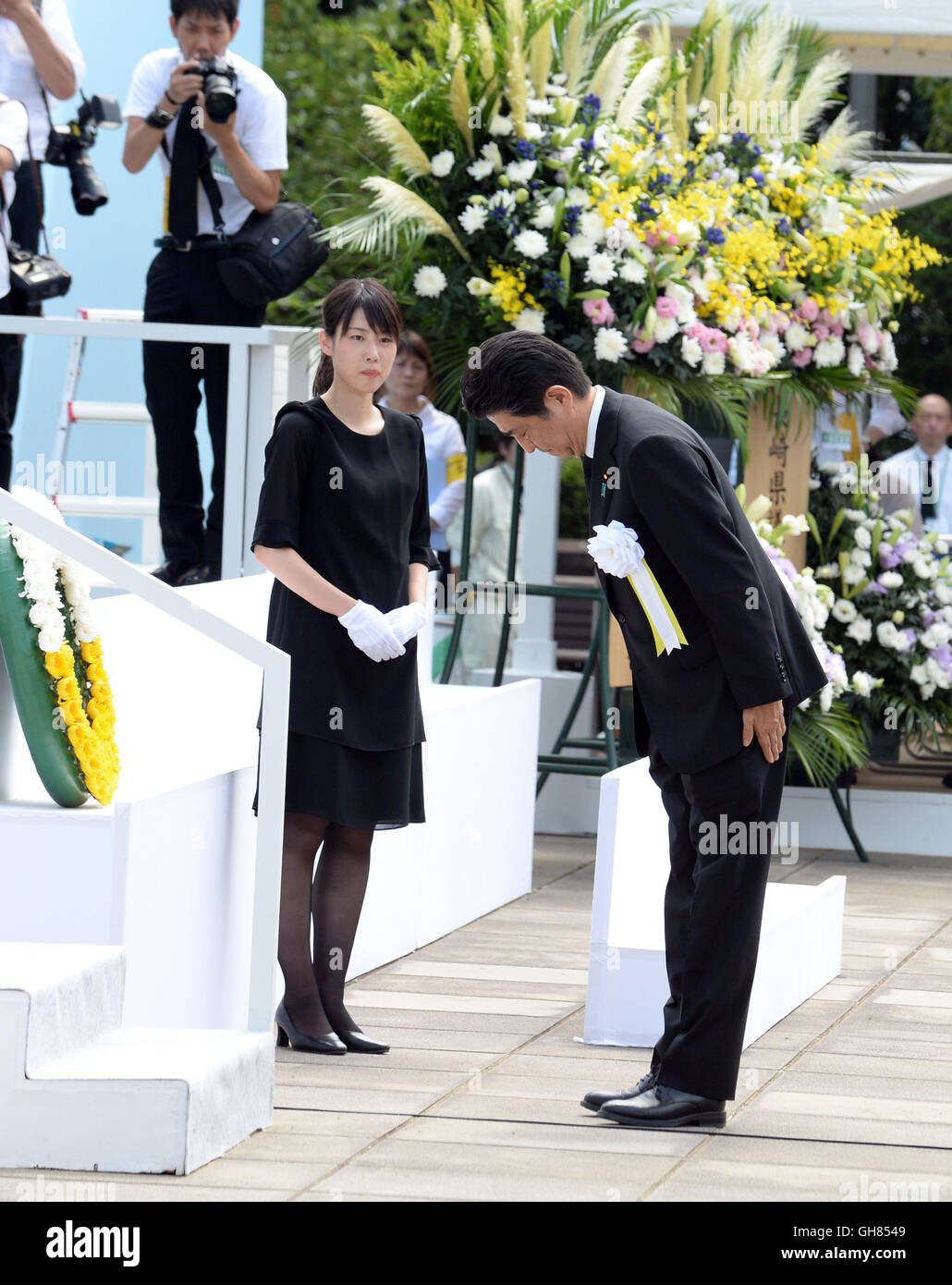 Nagasaki. 9th Aug, 2016. Japanese Prime Minister Shinzo Abe (R) bows during a ceremony commemorating the 71st anniversary of U.S. atomic bombing at the Peace Park in Nagasaki, on Aug. 9, 2016. To accelerate Japan's surrender in the World War II, the U.S. forces dropped two atomic bombs on Hiroshima and Nagasaki respectively on Aug. 6 and 9, 1945. Credit:  Ma Ping/Xinhua/Alamy Live News Stock Photo