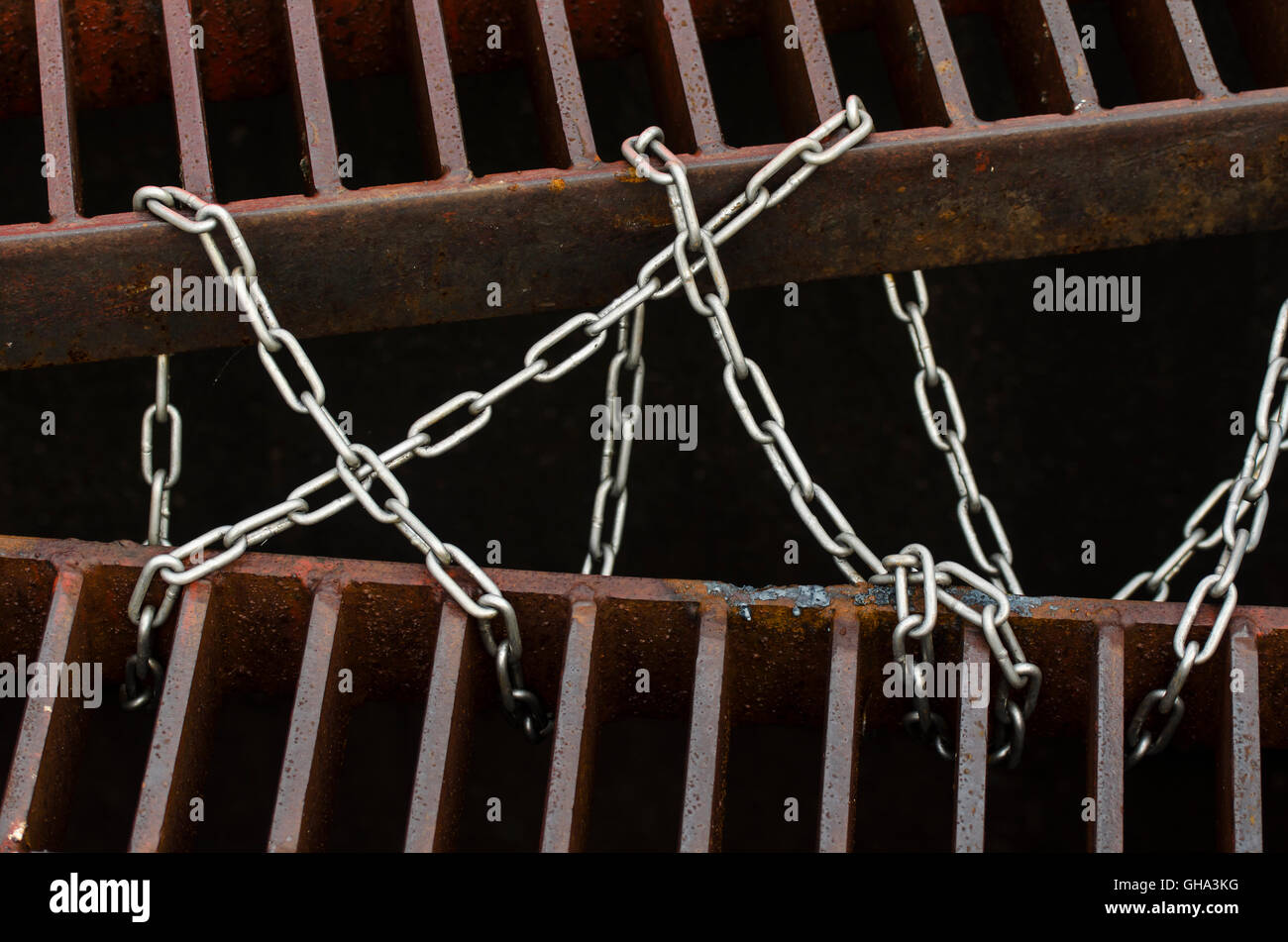 Chain tied drain cap, iron and steel background Stock Photo