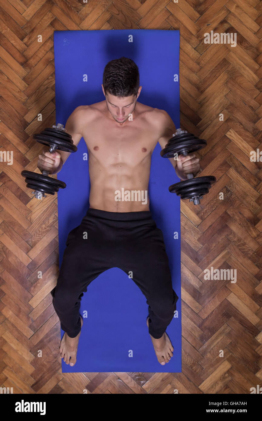 Young man abs dumbbell elevated view Stock Photo