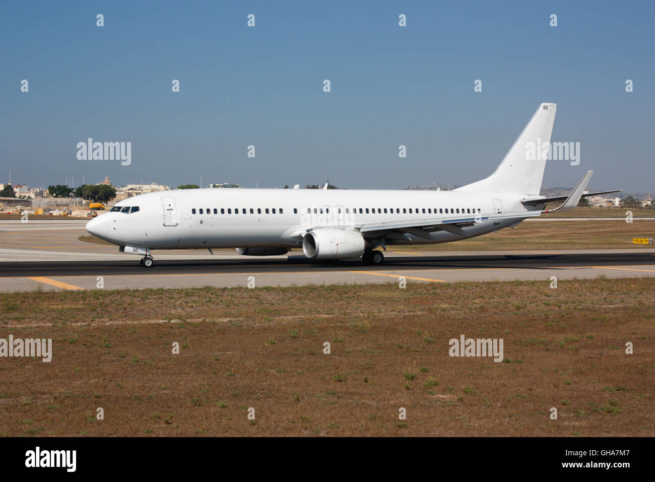 Modern aviation and air travel. Boeing 737 NG commercial jet plane taxiing on airport taxiway. No livery or logos and no faces visible. Stock Photo