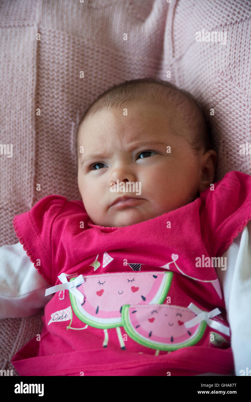 Grumpy face newborn baby in watermelon top Stock Photo Alamy