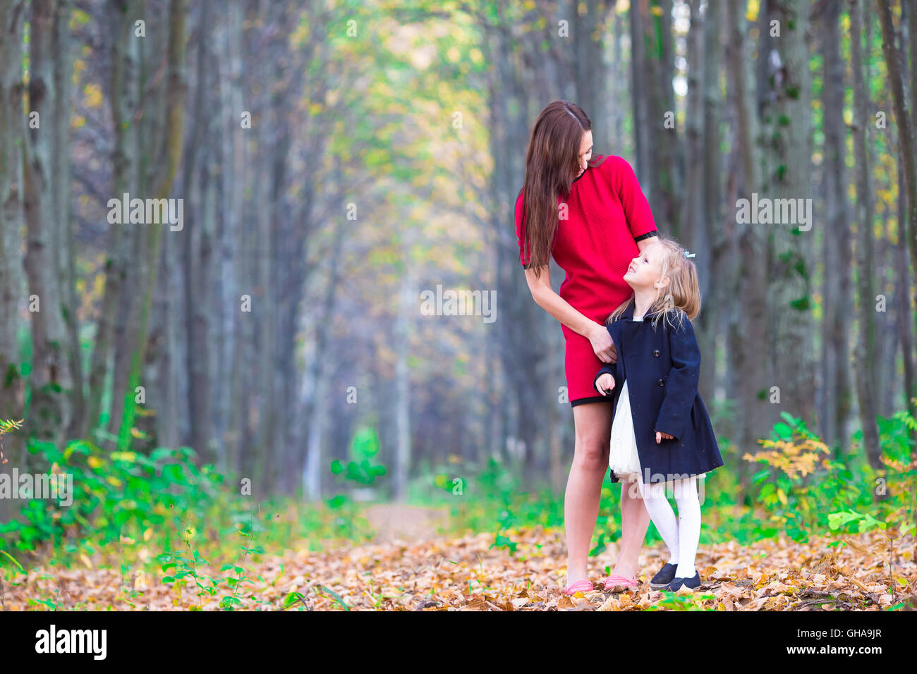 Adorable little girl with mother in autumn park outdoors Stock Photo ...