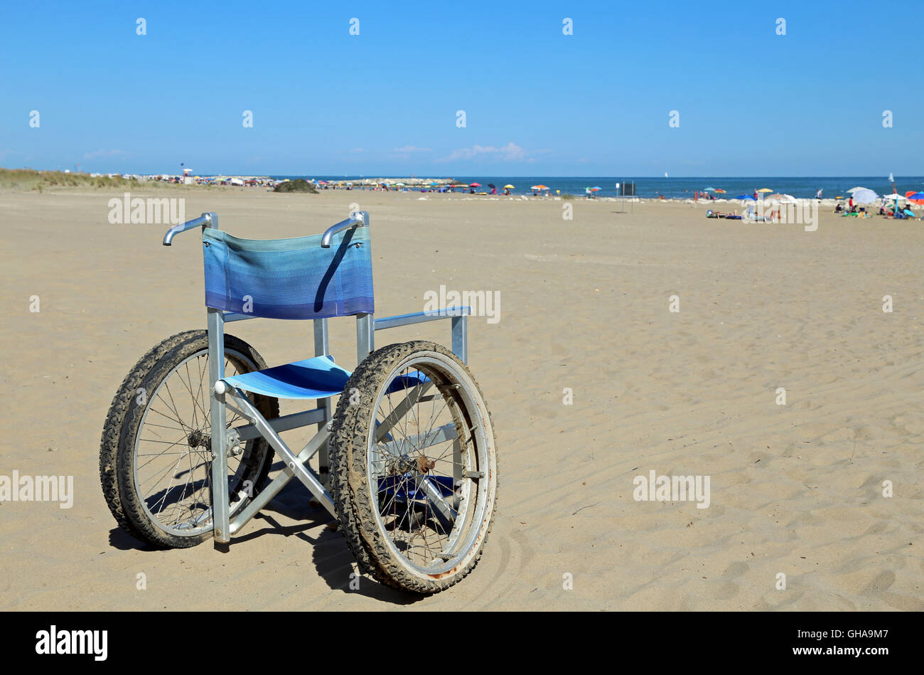 isolated wheelchairs for people with mobility problems on the sea beach in summer Stock Photo