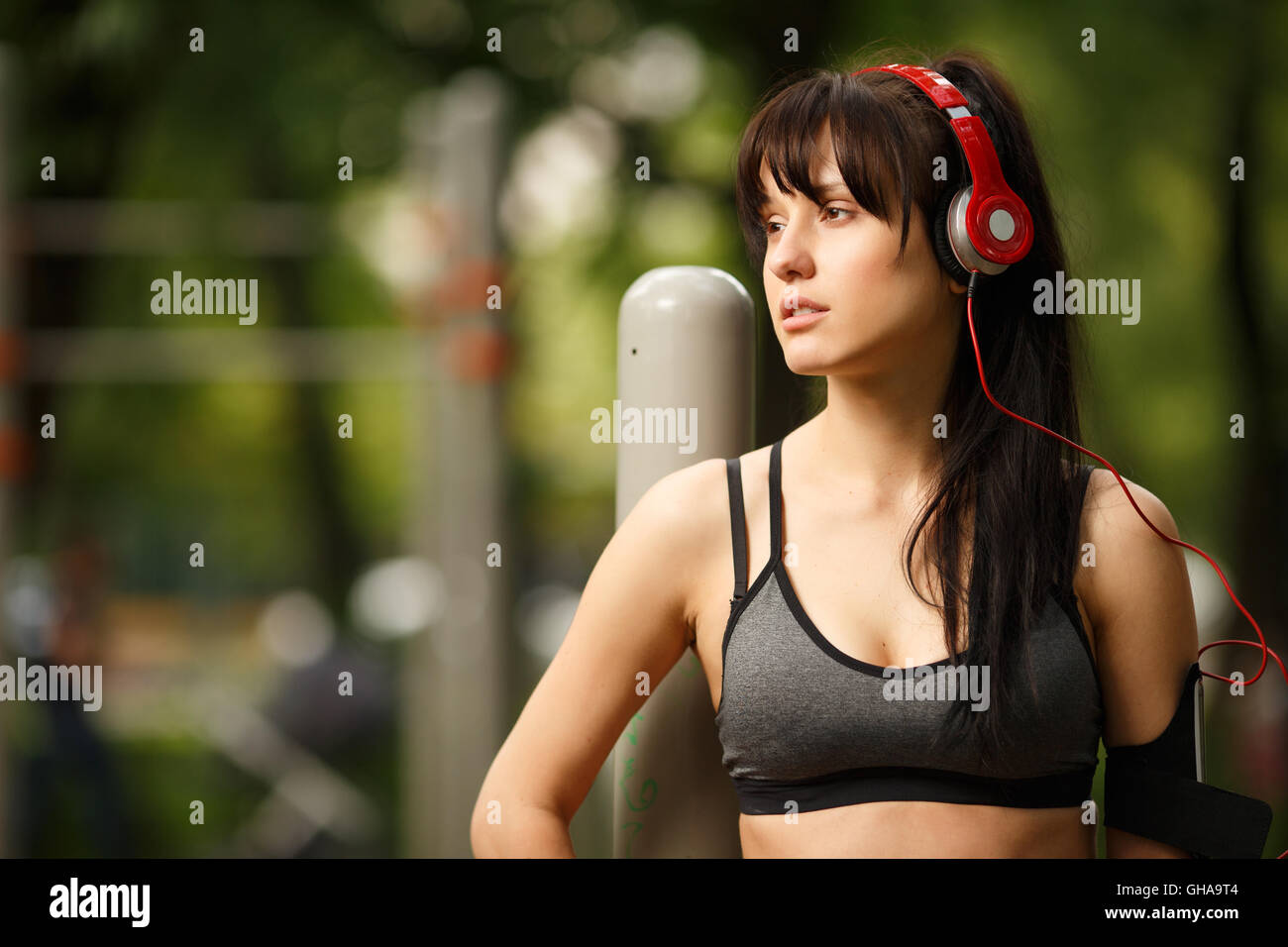Portrait of dark-haired athletic young woman in big headphones Stock Photo