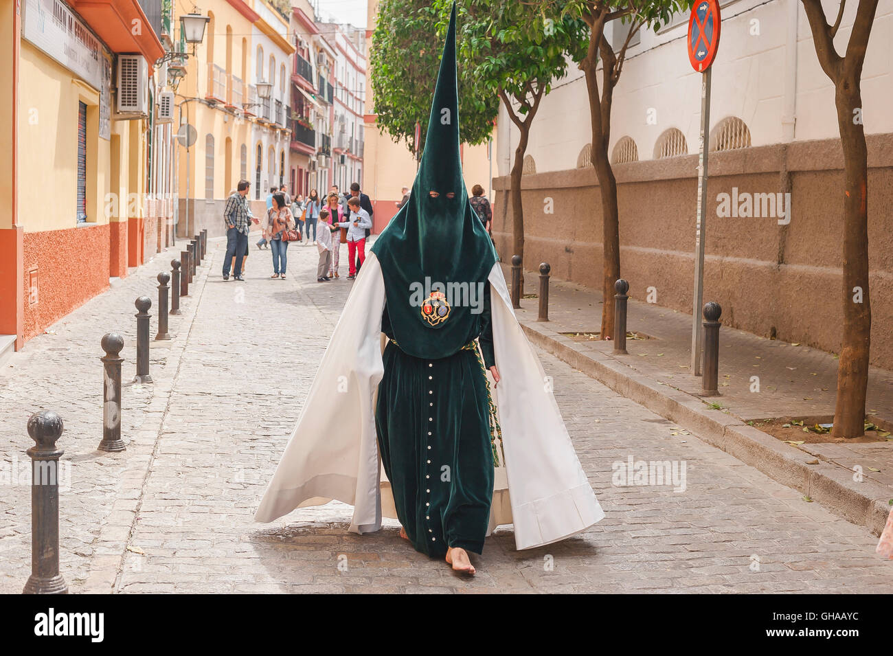 Seville Semana Santa, a member of a hooded cofradia (brotherhood) walks to attend his procession in the Easter Holy Week festival in Seville, Spain. Stock Photo