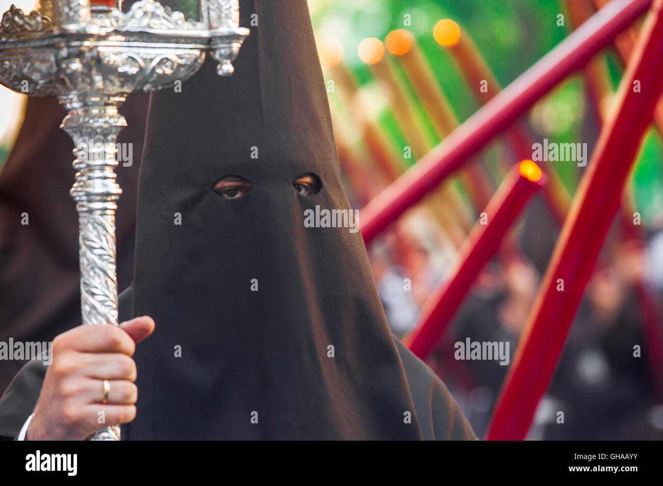 Spain festival, a member of a hooded cofradia (brotherhood) walks in a procession in the Easter Holy Week (Semana Santa) festival in Seville, Spain. Stock Photo