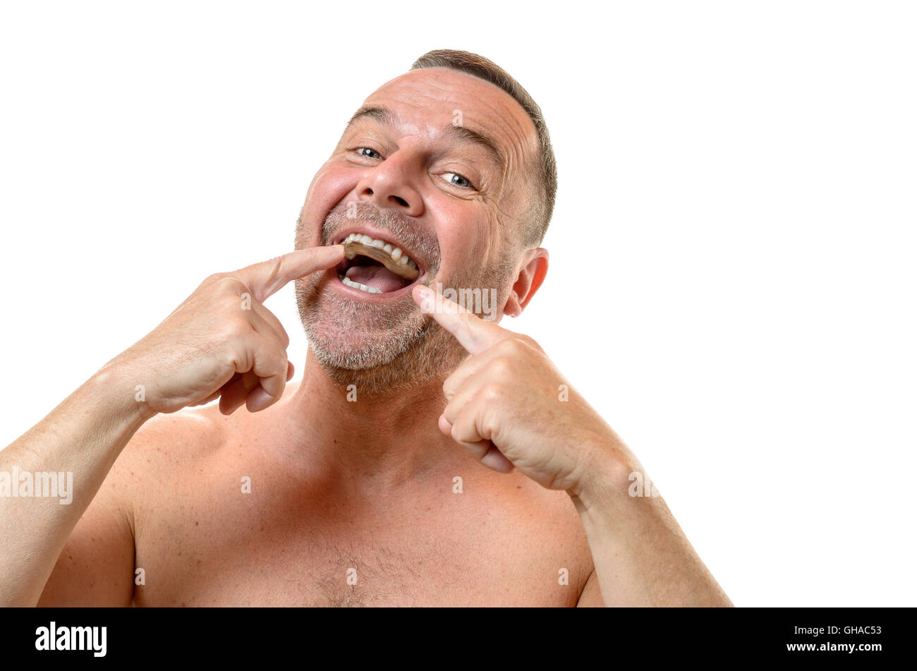 Bare Chested Man With Short Hair And Stubble Points To Teeth With
