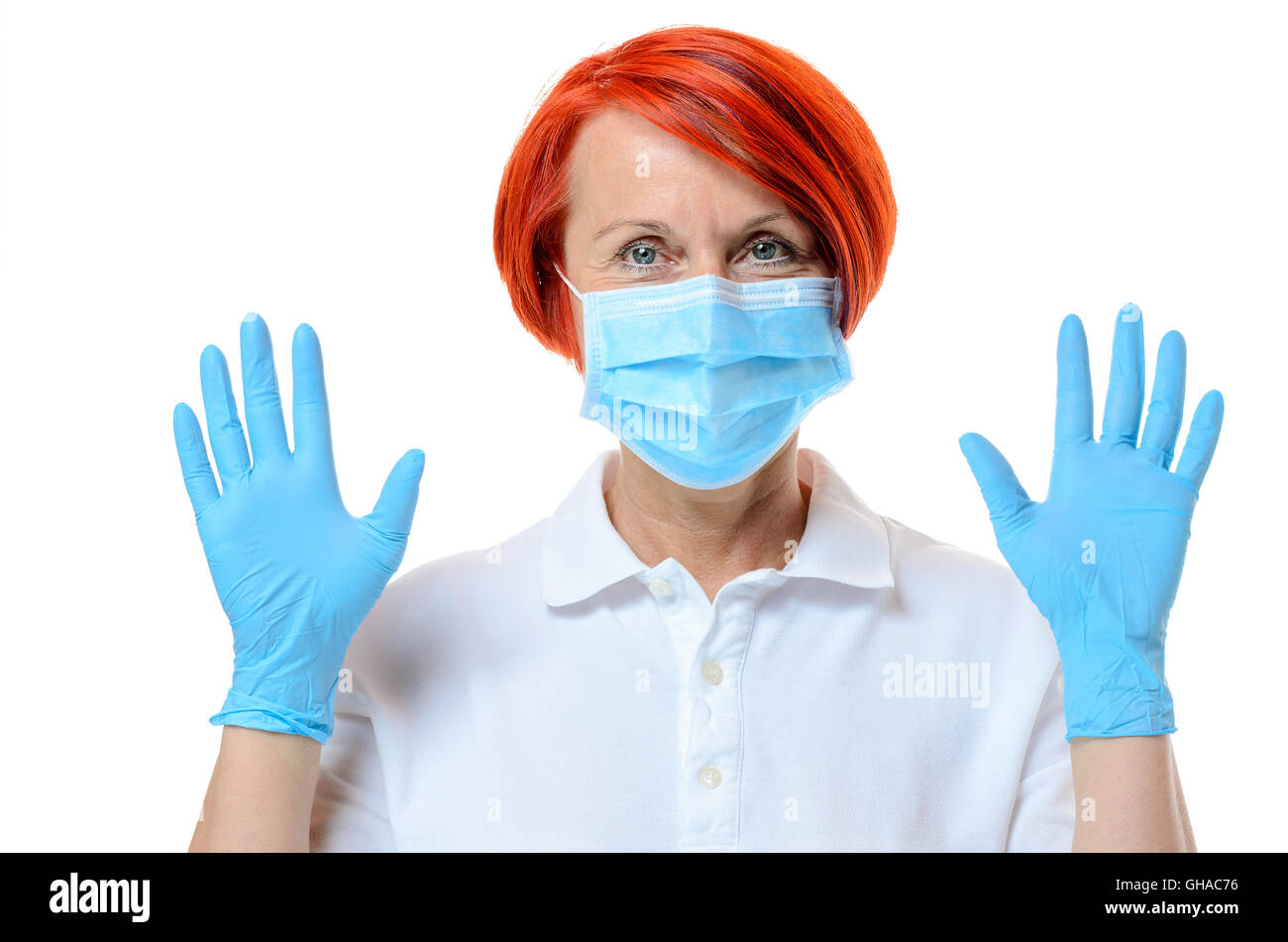 Close up of red headed nurse wearing face mask and blue rubber gloves ...