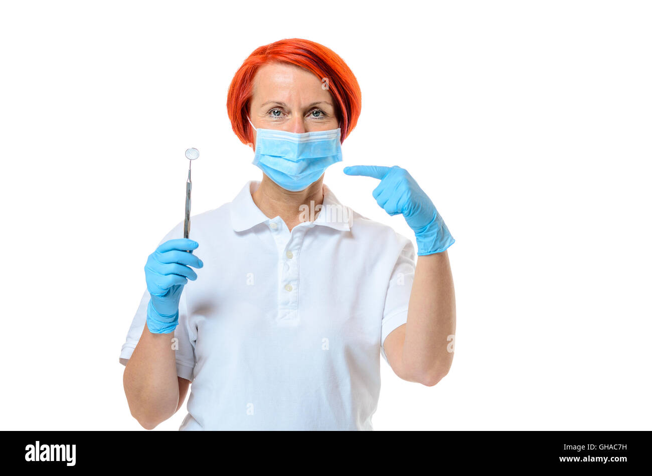 Female dentist wearing blue face mask and rubber gloves while pointing