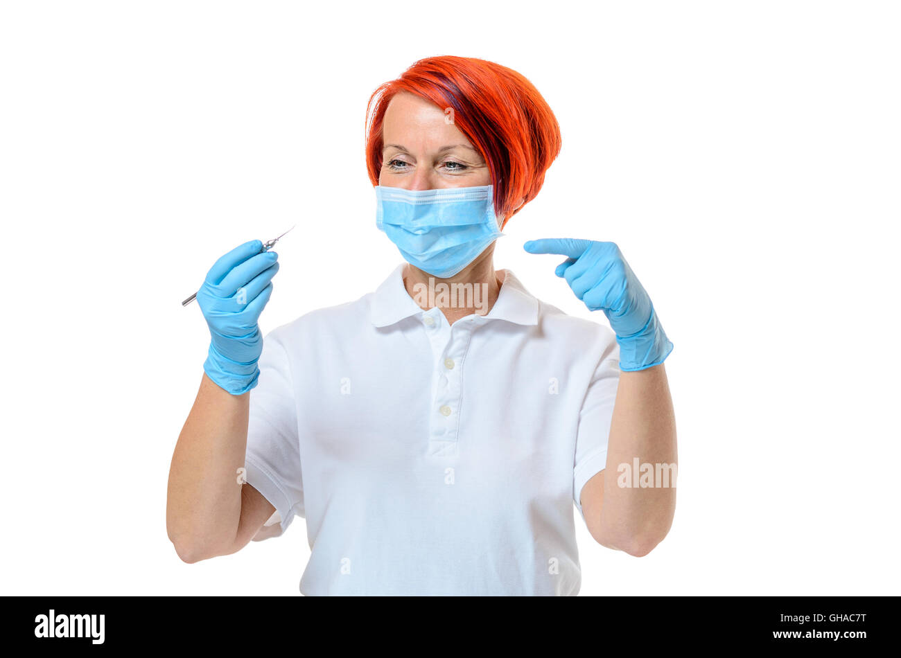 Female dentist wearing face mask and rubber gloves points toward sharp