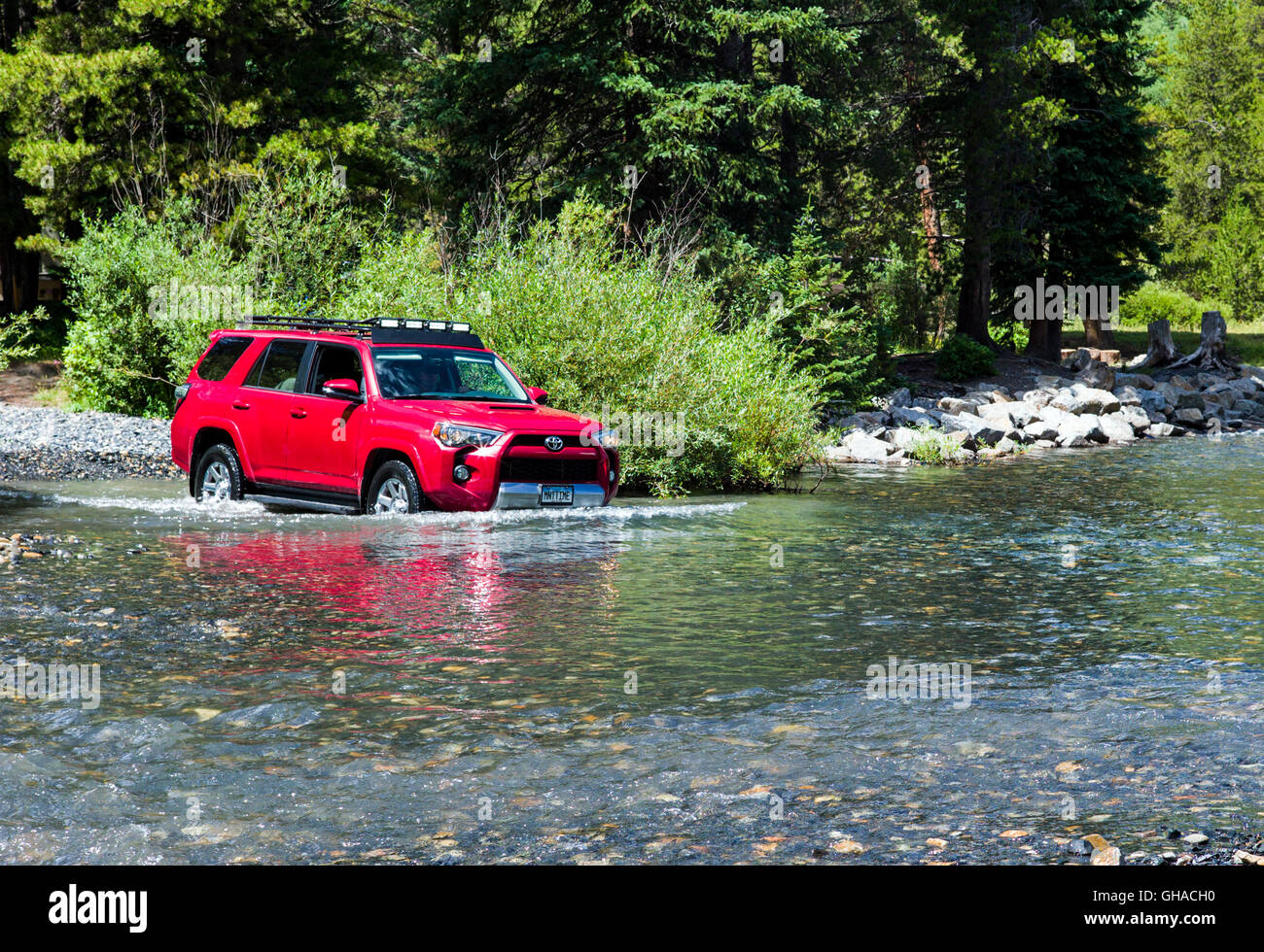 Red 2014 Toyota 4Runner Trail Premium on rough four wheel drive 4WD road, crossing Slate River, Crested Butte, Colorado, USA Stock Photo